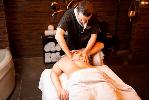 Professional masseur doing a deep massage to a male client at Spa salon, shoulder massage